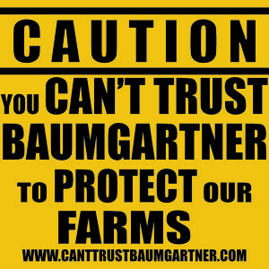 Image of a yard sign reading "Caution you can't trust Baumgartner to protect our Farms."